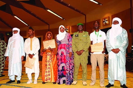 Les officiels pausant avec les trois lauréats des concours (Photo ANP)